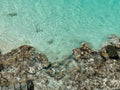 Close-up of rocky shoreline with clear turquoise water