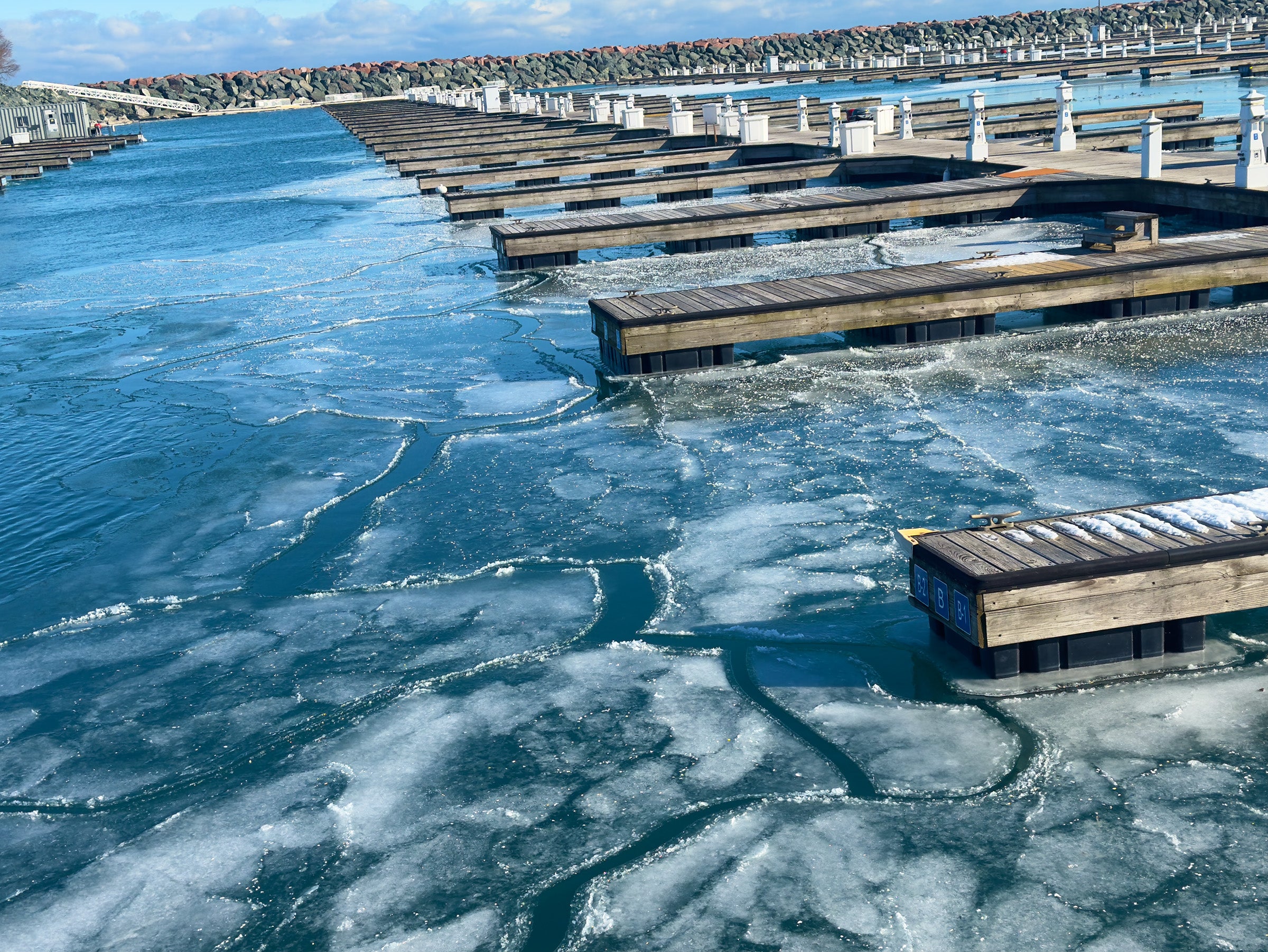 Frozen harbor with ice-covered water and wooden docks.